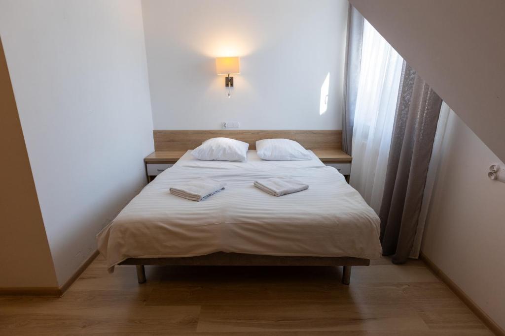 Cozy bedroom with a double bed, white linens, and soft lighting.