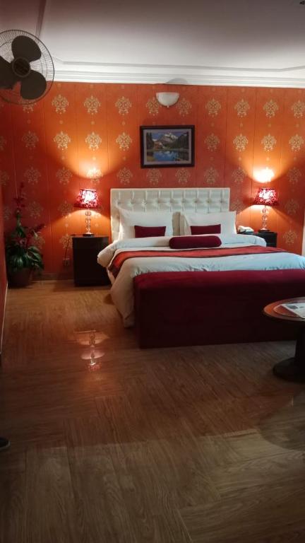 マリーにあるHotel Sunway Murreeのベッドルーム1室(オレンジ色の壁の大型ベッド1台付)