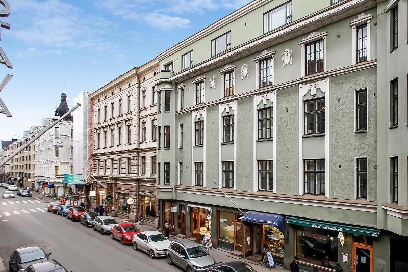 a city street with cars parked in front of buildings at Luxhousing apartment with balcony in Helsinki