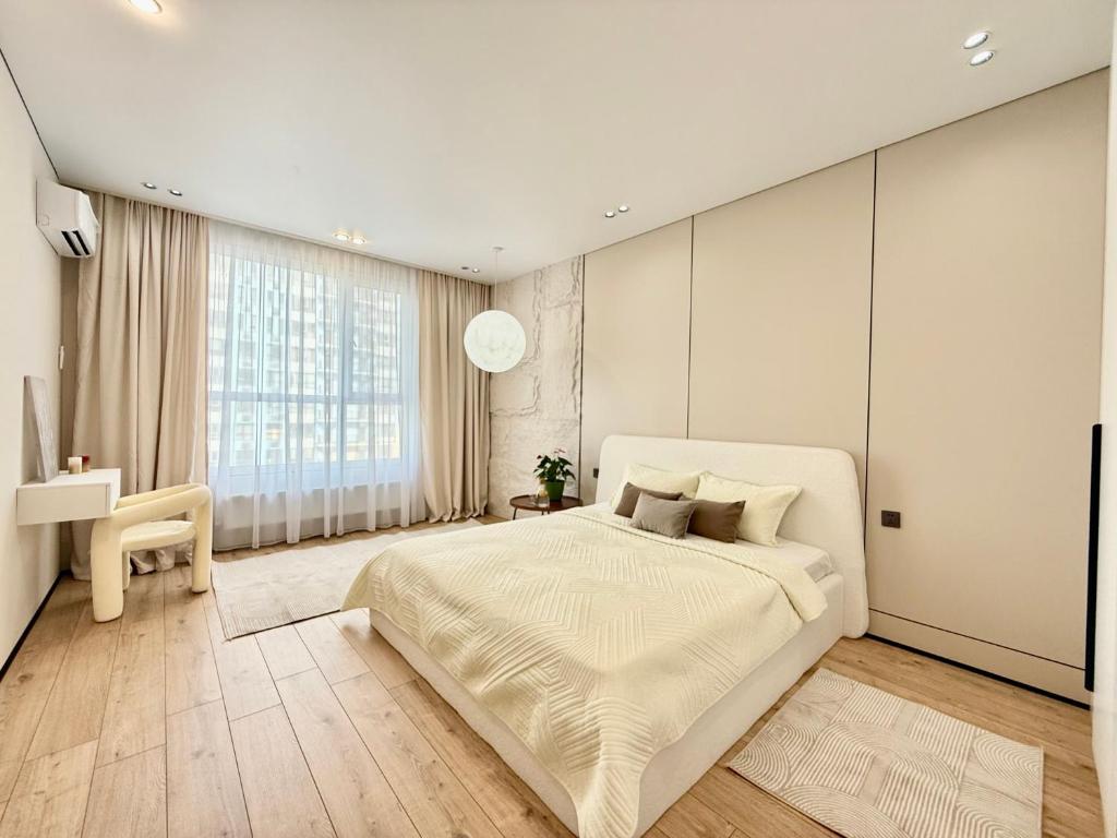 a bedroom with a large bed and a large window at ЖК КРИСТАЛЛ Бизнес класс in Almaty