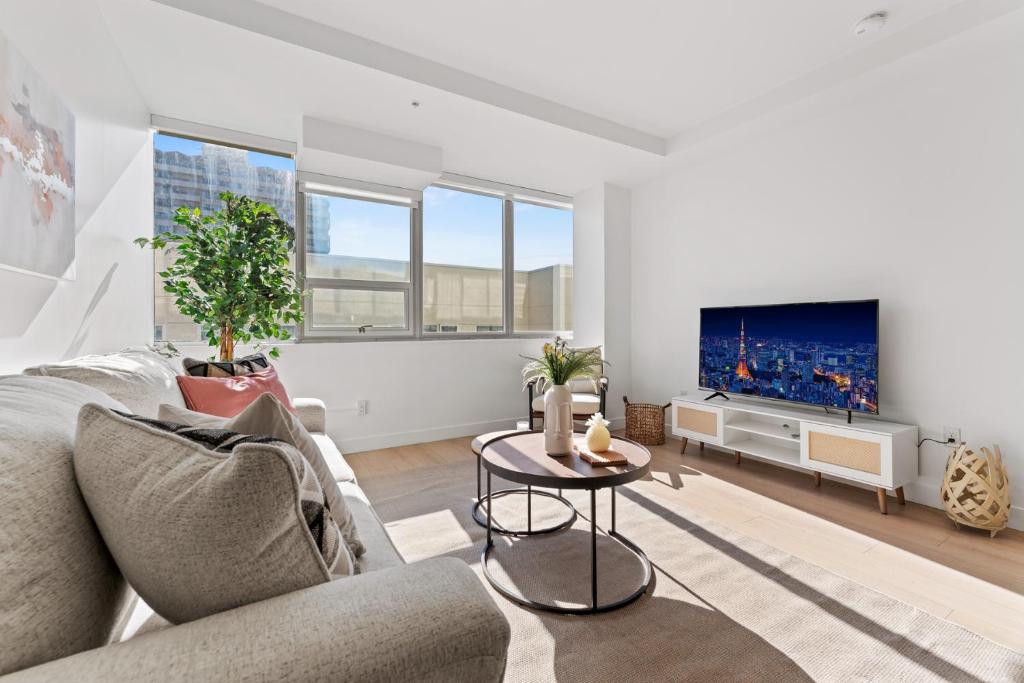 Una sala de estar con un sofá y un televisor. en Modern Retreat in Koreatown - Perfect for Your LA Stay!, en Los Ángeles