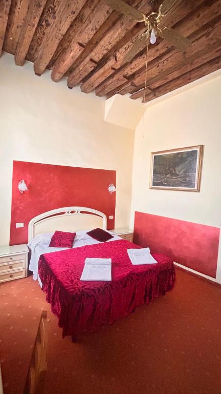 um quarto com uma cama grande e uma cabeceira vermelha em Casa Lin Venice Zimmer em Veneza