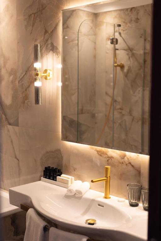 a white bathroom with a sink and a shower at Baltic Beach Hotel & SPA in Jūrmala