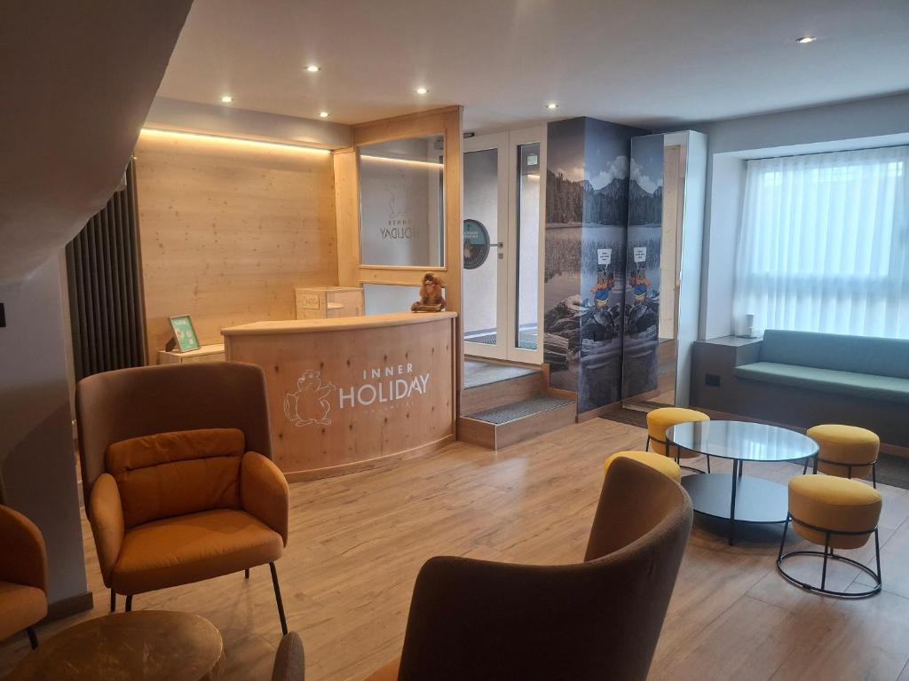 a salon with chairs and a table and a waiting room at Inner Holiday Dolomites in Dimaro