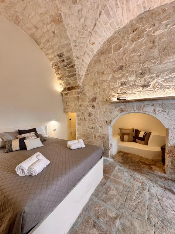 a bedroom with a large bed in a stone wall at Bianca Ostuni in Ostuni