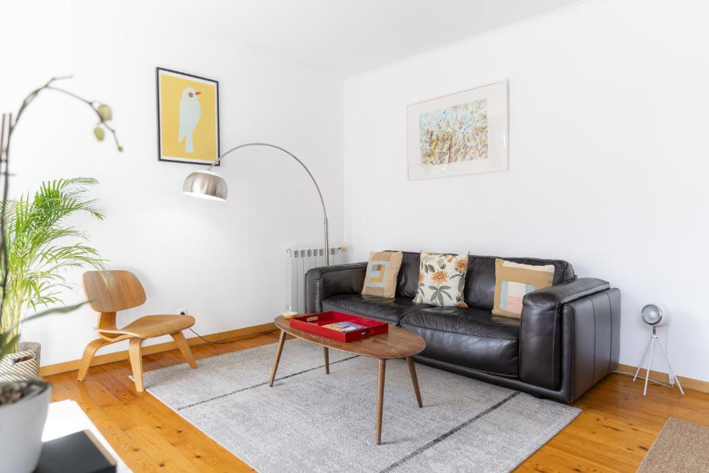 リスボンにあるLV Premier Apartments Baixa- PRのリビングルーム(黒い革張りのソファ、テーブル付)
