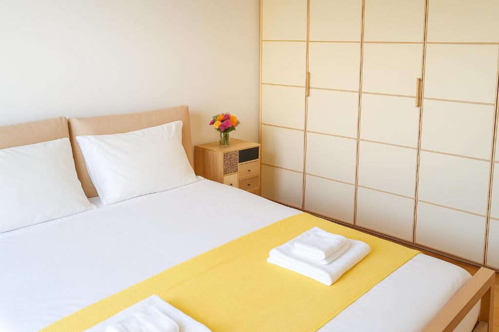 a small bedroom with a bed with a yellow and white bedspread at Zen Garden House - in front of the metro in Pero