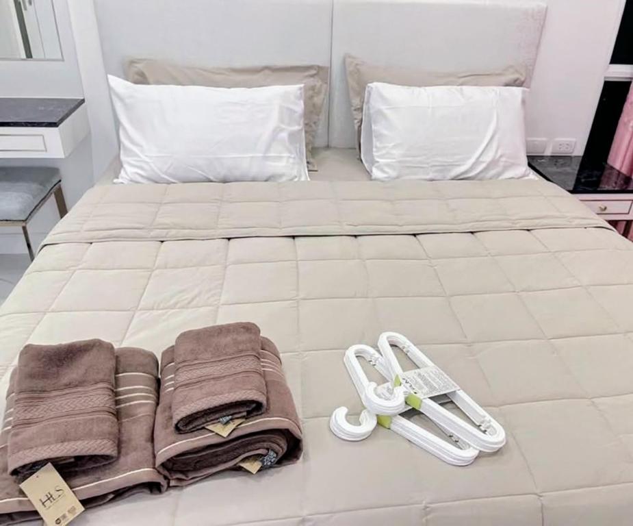 een wit bed met handdoeken en slippers erop bij ห้องใหม่ใกล้ทะเล in Jomtien Beach