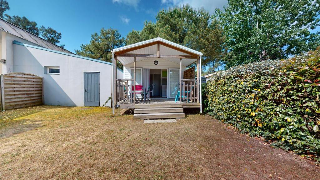 un hangar blanc avec un porche et des escaliers dans l'établissement Azur Ocean avec terrasse, à Saint-Jean-de-Monts