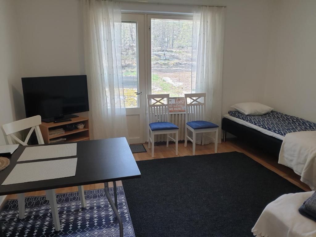 a room with a bed and a tv and a table at Studio Aalto in Taalintehdas