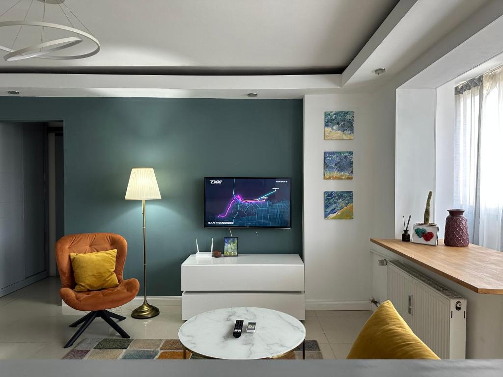 a living room with a chair and a tv on a wall at 2 rooms condo in city center in Bucharest