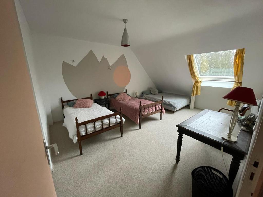 a bedroom with a bed and a couch and a table at Maison du WHITE ROCK in Saint-Jouan-des-Guérets