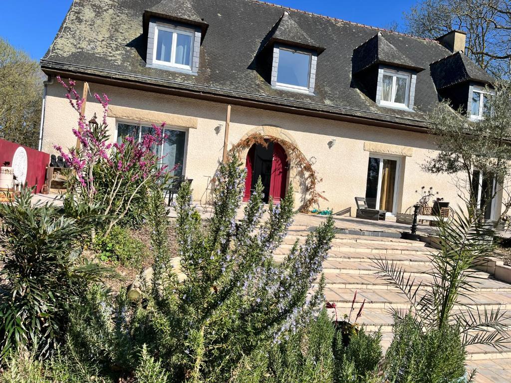a house with a red door and some plants at Maison du WHITE ROCK in Saint-Jouan-des-Guérets