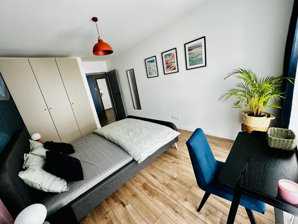 a living room with a bed and a table and a chair at PURA Vida in Gdynia