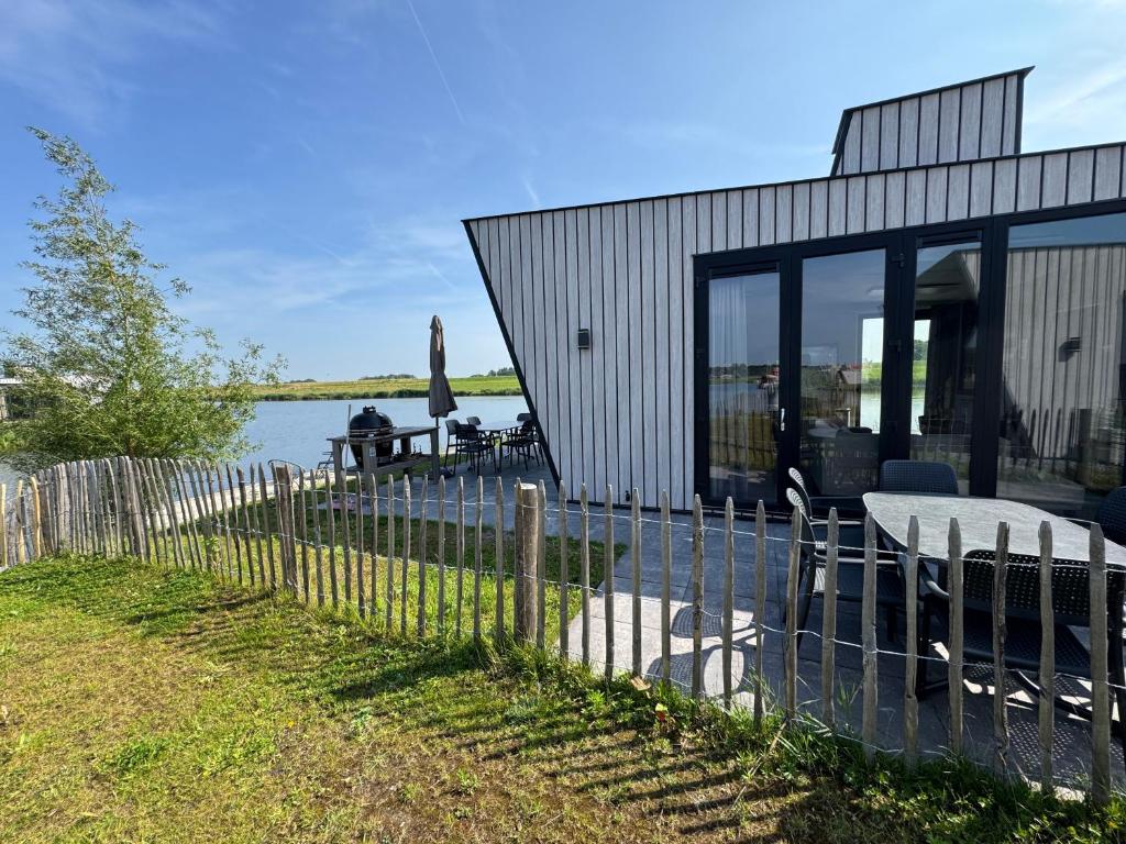 una casa con una recinzione accanto all'acqua di De IJssel Eilanden Chalet Laguna Kampen mit Zaun Nr 754 a Kampen