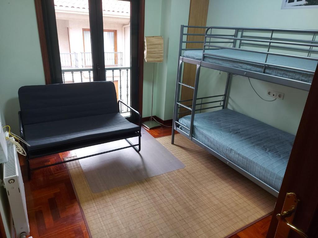 a room with two bunk beds and a chair at Apartamento 2 habitaciones con garaje in Gondomar