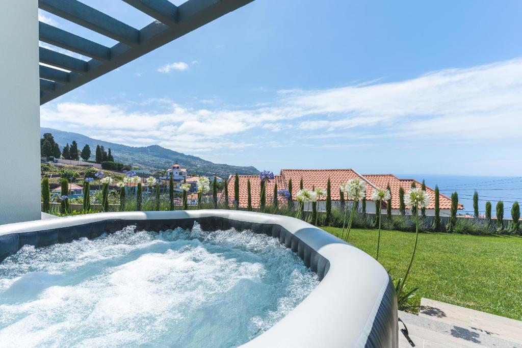 a hot tub in a backyard with a view of the ocean at Sapphire Sands by Atlantic Holiday in Estreito da Calheta