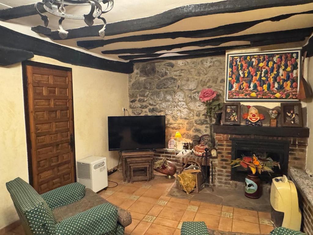 a living room with a fireplace and a television at Casa rural carrales in Matienzo