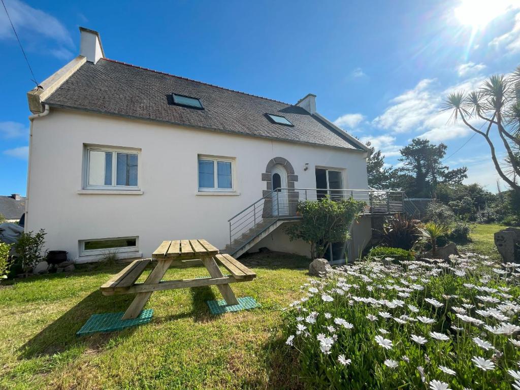 - une table de pique-nique devant une maison blanche dans l'établissement Appartement dans une maison avec entrée indépendante à 500m de la plage, à Santec