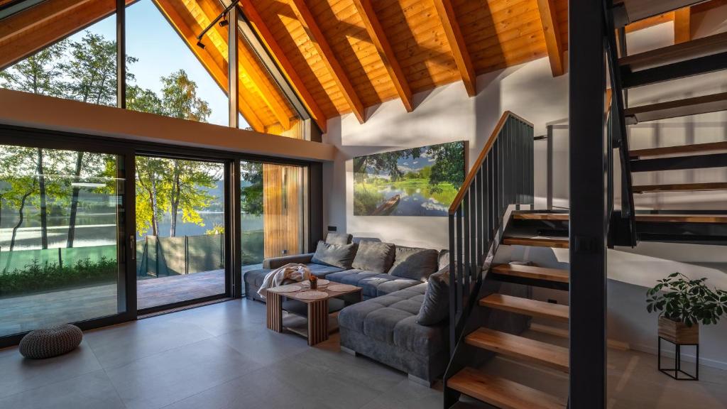 a living room with a couch and a staircase at Lipno - Luxury Lake Villa in Nové Domky