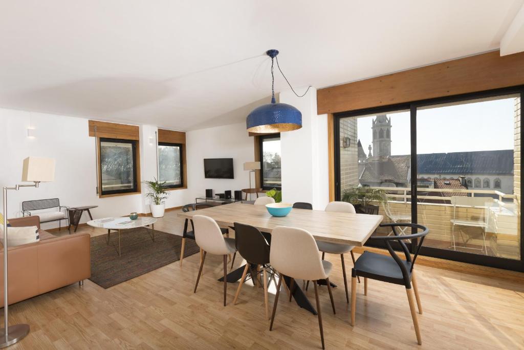 a dining room and living room with a table and chairs at LV Premier Marques MQ2 in Porto