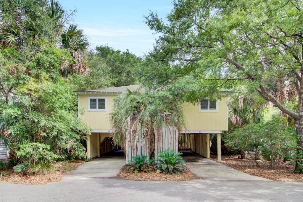a house with a palm tree in front of a driveway at Sandpiper Court 14 by Wild Dunes, with Amenities in Isle of Palms