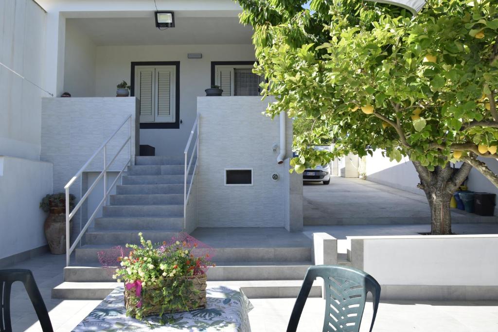 a house with stairs and a table with flowers on it at A Casuzza in Salemi