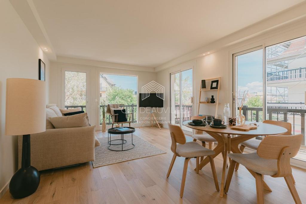 un salon avec une table et un canapé dans l'établissement Les Prairies de Deauville Plein centre CLS, à Deauville
