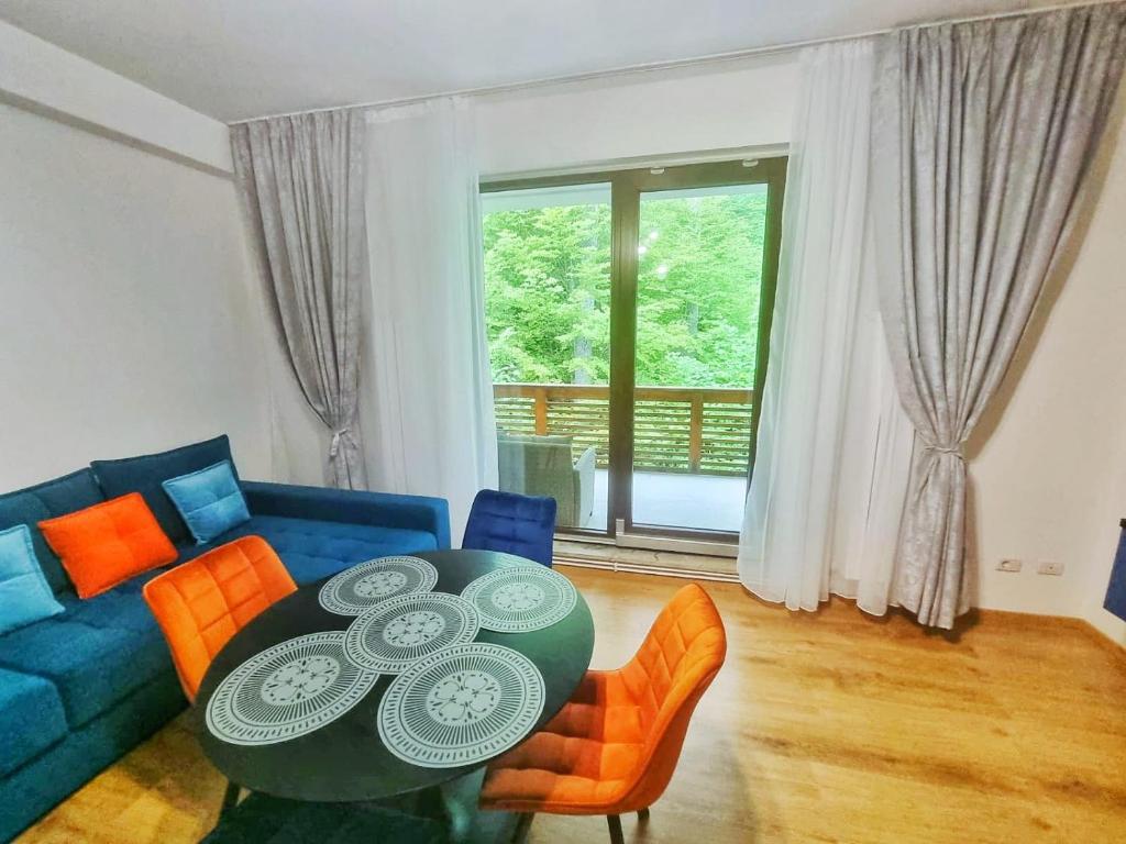 a living room with a blue couch and a table at Alpin Confort Predeal in Predeal