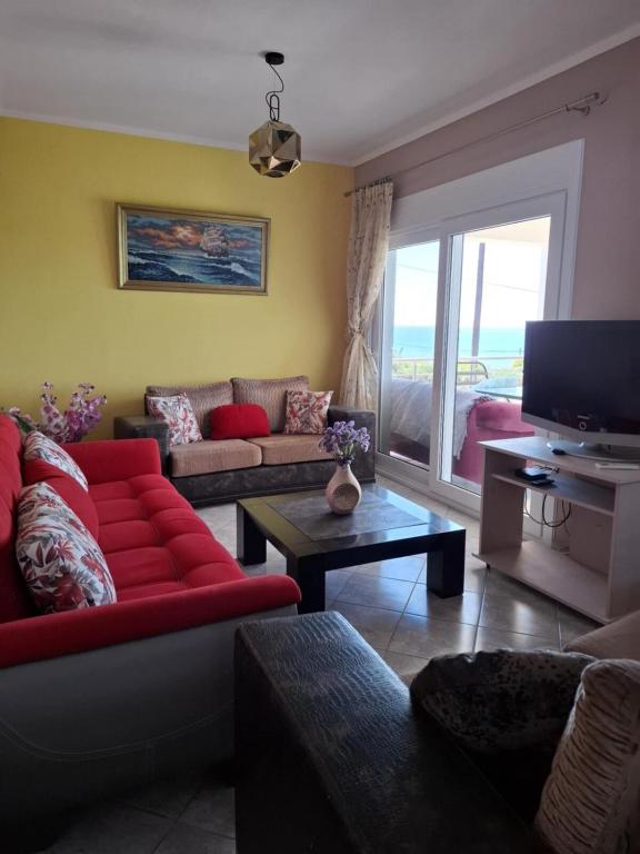 a living room with a red couch and a television at Myriam&Ioanna Seaside Apartment in Chios