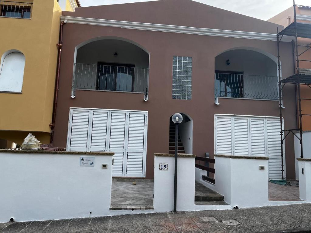 a house with two garage doors and two balconies at La rosa dei venti in Santa Teresa Gallura