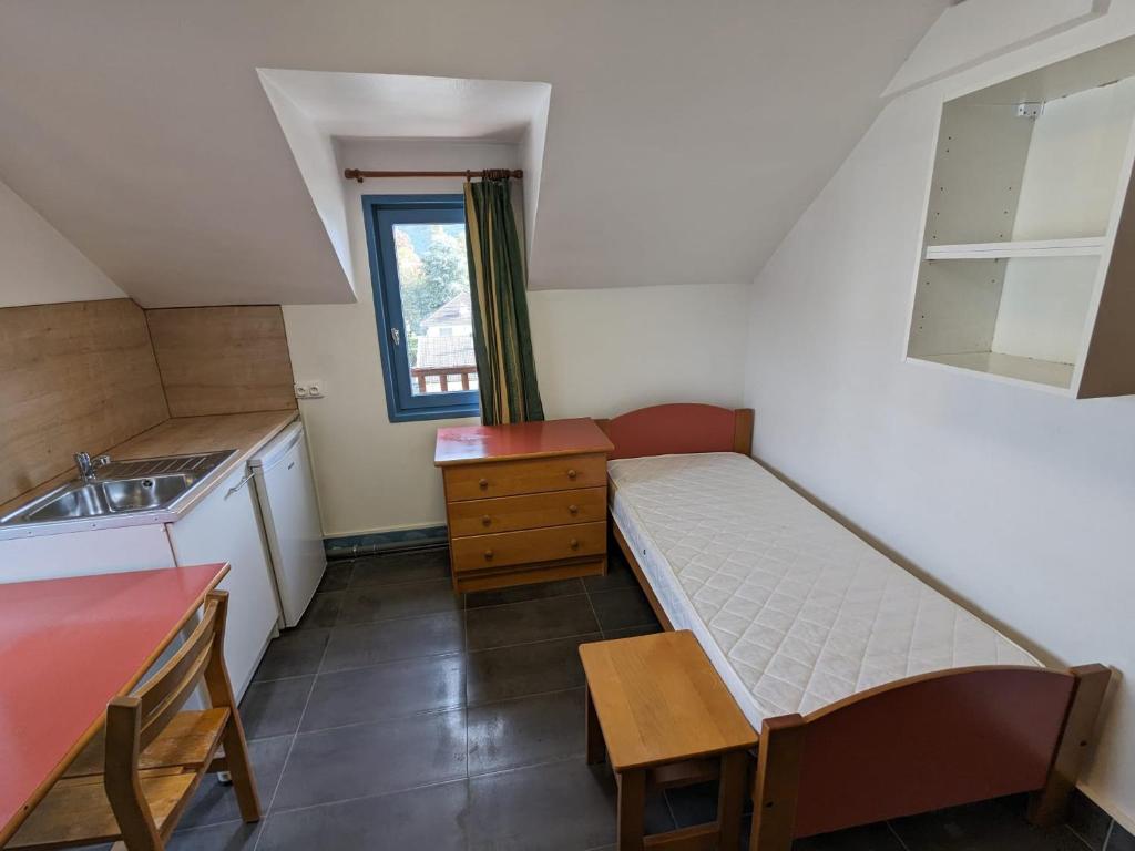 Cette petite chambre comprend un lit et un lavabo. dans l'établissement Studio Chambery Centre with shared toilets, à Chambéry