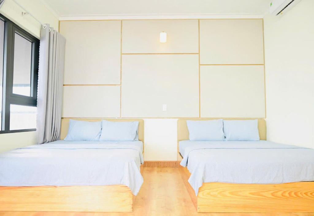 due letti uno accanto all'altro in una stanza di The Sunset a Phan Thiet