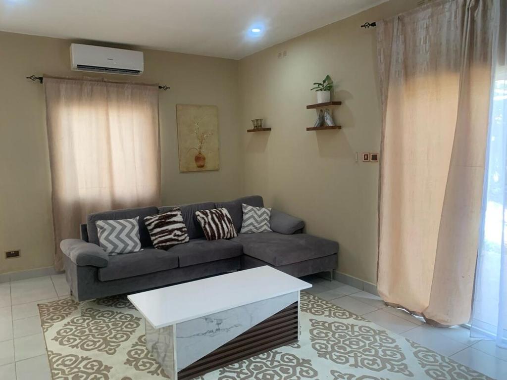 a living room with a couch and a table at Cozy 2BR Bungalow Senegambia in Serekunda