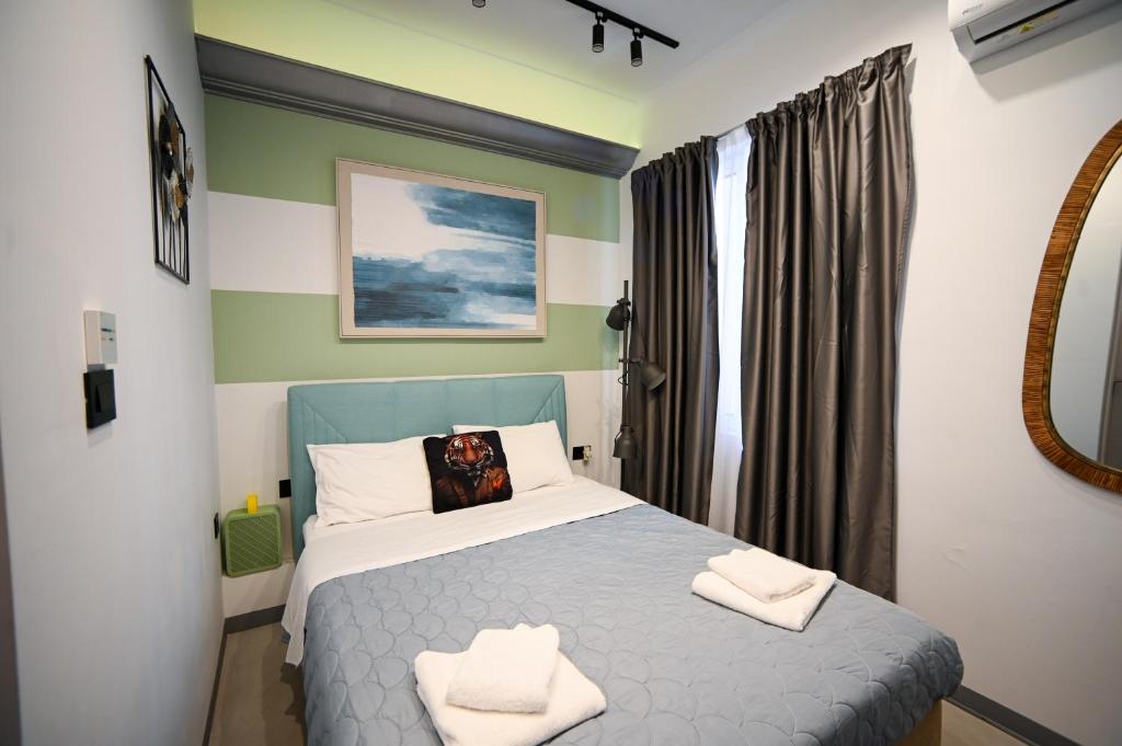 a bedroom with a bed with two towels on it at Hermes Suite Klathmonos by Zeussuites in Athens