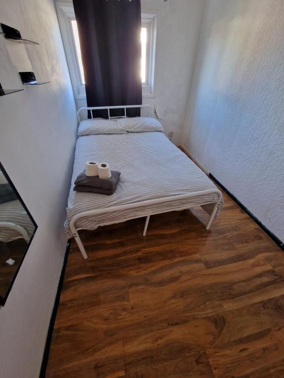 a small room with two beds and two towels at Cosy Beds & Rooms in London