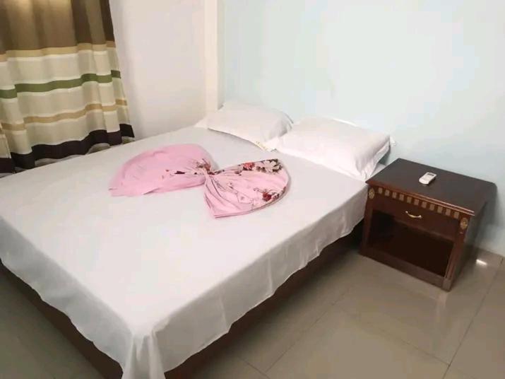 un letto con un fiocco rosa sopra di Monsoleil a Luanda