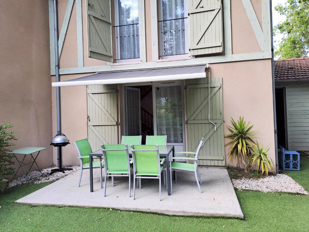 une table et des chaises devant une maison dans l'établissement La gemmeuse, à Aureilhan