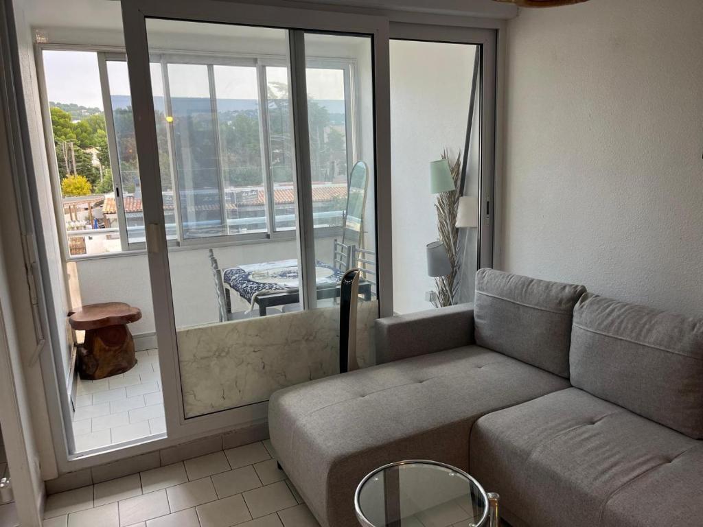 un salon avec un canapé et une grande fenêtre dans l'établissement T2 proche des plages, à Sète