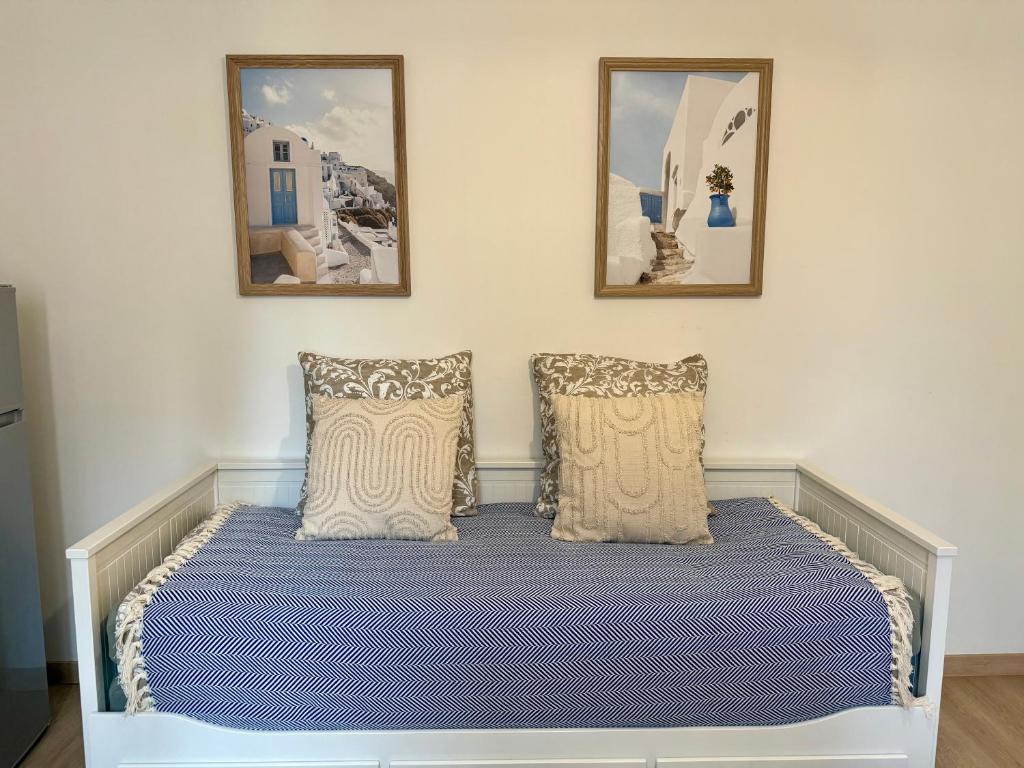 a bed in a room with two pictures on the wall at Le Herriot 3 - Proche de la gare in Brive-la-Gaillarde