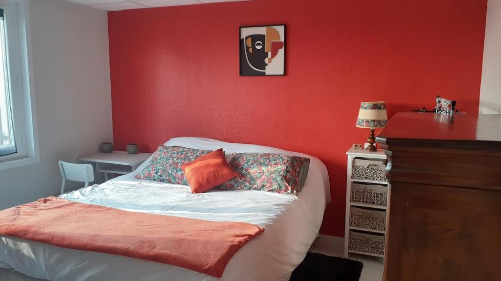 - une chambre dotée d'un lit avec un mur rouge dans l'établissement Réz de Jardin, à Saint-Martin-du-Mont