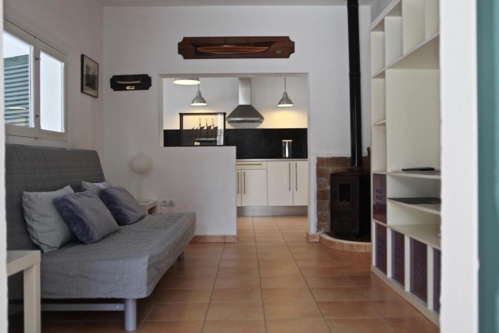 a living room with a couch and a kitchen at Casa Nena Es Calo in Es Caló