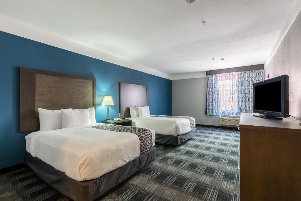 Postel nebo postele na pokoji v ubytování Platinum Inn & Suites Webster