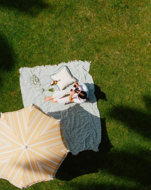 a group of people laying on a blanket with an umbrella at The Milo in Santa Barbara