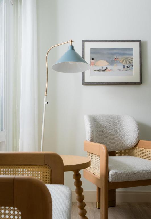 a living room with a table and a chair and a lamp at The Milo in Santa Barbara