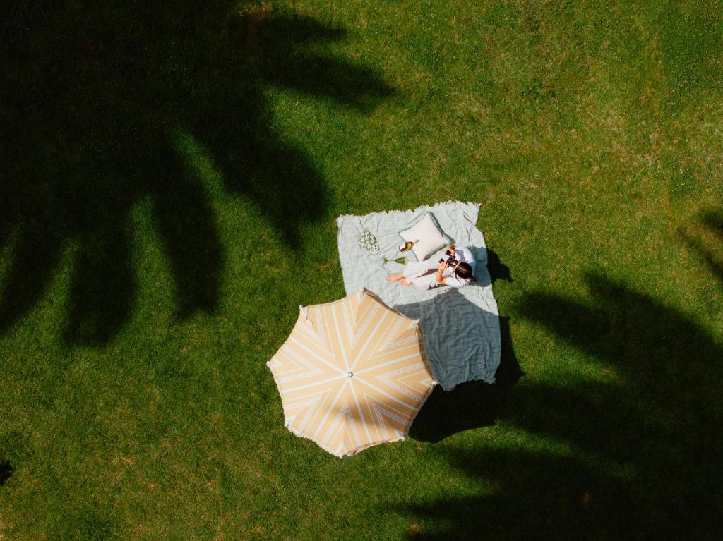 an overhead view of a table with an umbrella in the grass at The Milo in Santa Barbara