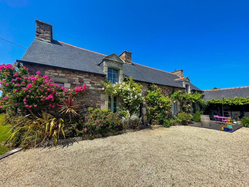an old stone house with flowers in front of it at Gîte de charme in Paimpol