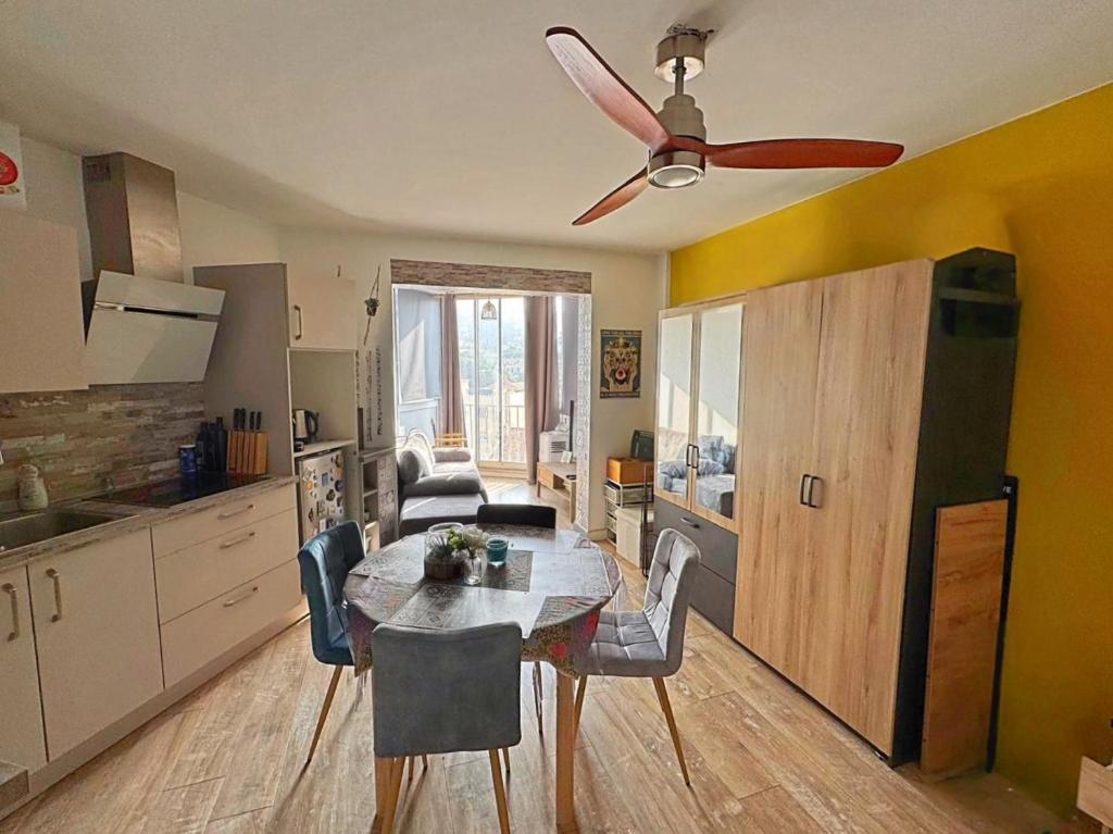 Il comprend une cuisine et une salle à manger avec une table et un ventilateur de plafond. dans l'établissement Charmant Studio - Centre Cannes, à Cannes