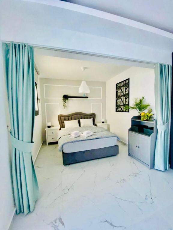 a bedroom with a king sized bed and blue curtains at Caesar Resort Apartments Marcellus 51 in Iskele
