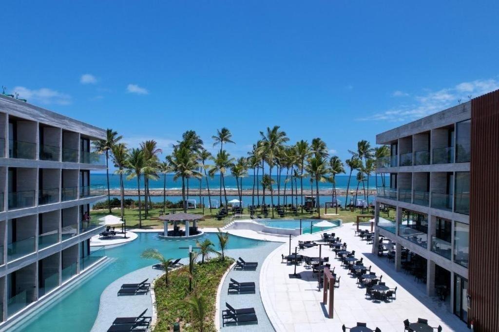 a view of a resort with a pool and palm trees at Porto Alto Resort ap 213 in Cupe